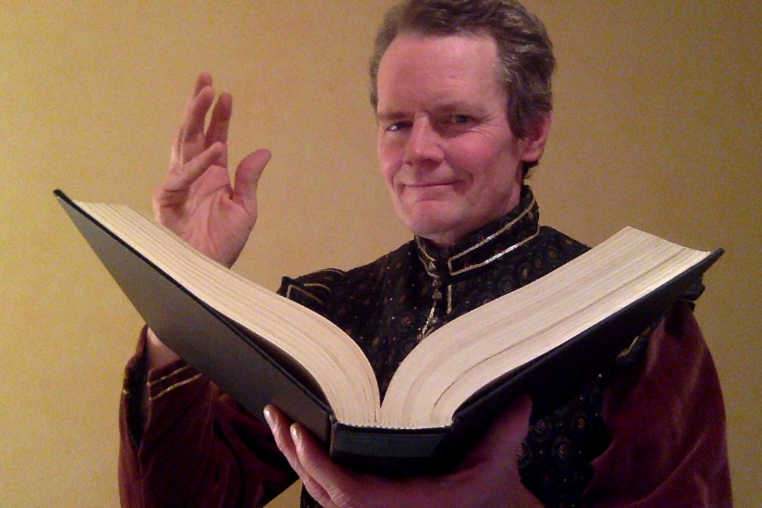 Kurtis Kelly holding a book dressed in Shakespearean costume