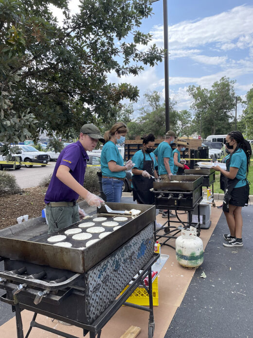 Event volunteers flipping pancakes