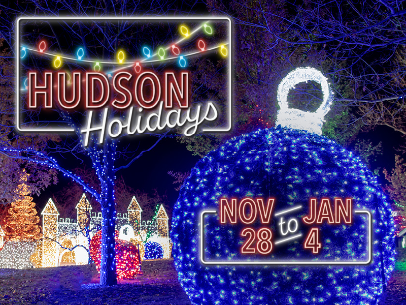 Large blue christmas ornament made of lights with a lighted castle maze in the background