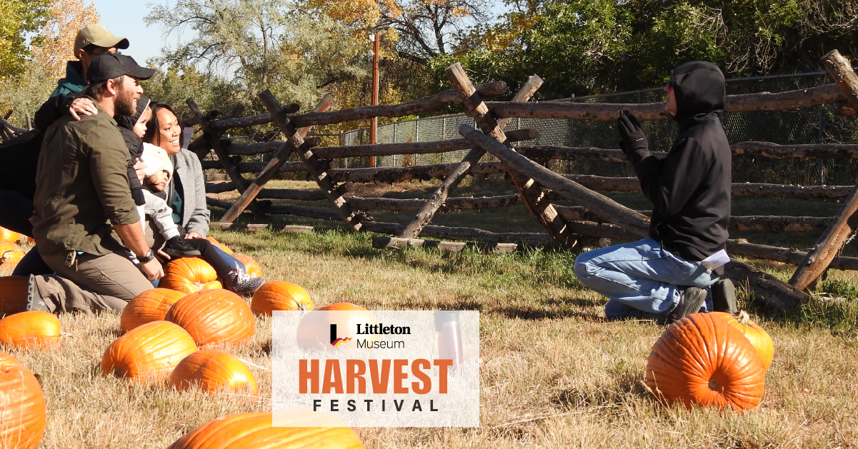 Photo of a family in a field of pumpkins, smiling and posing for a photo